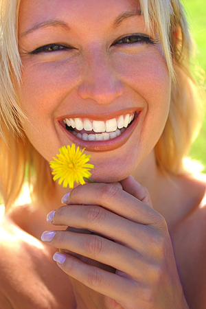Smiling woman holding yellow flower