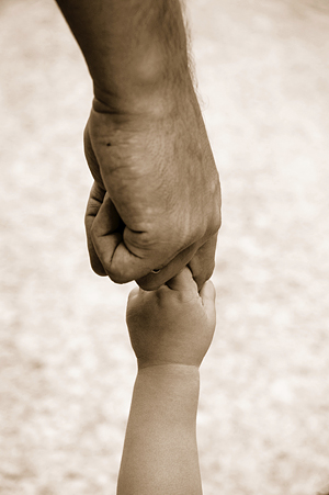 Holding Hands. An adult hand holds a child's hand